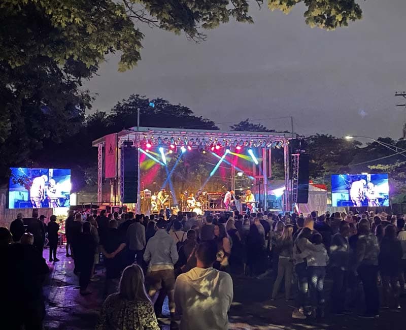 Large-format LED screens and crowd at an outdoor evening event